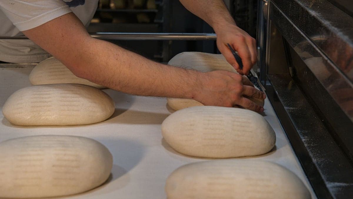 Bäcker formt Brot in einer handwerklichen Bäckerei in Berlin.