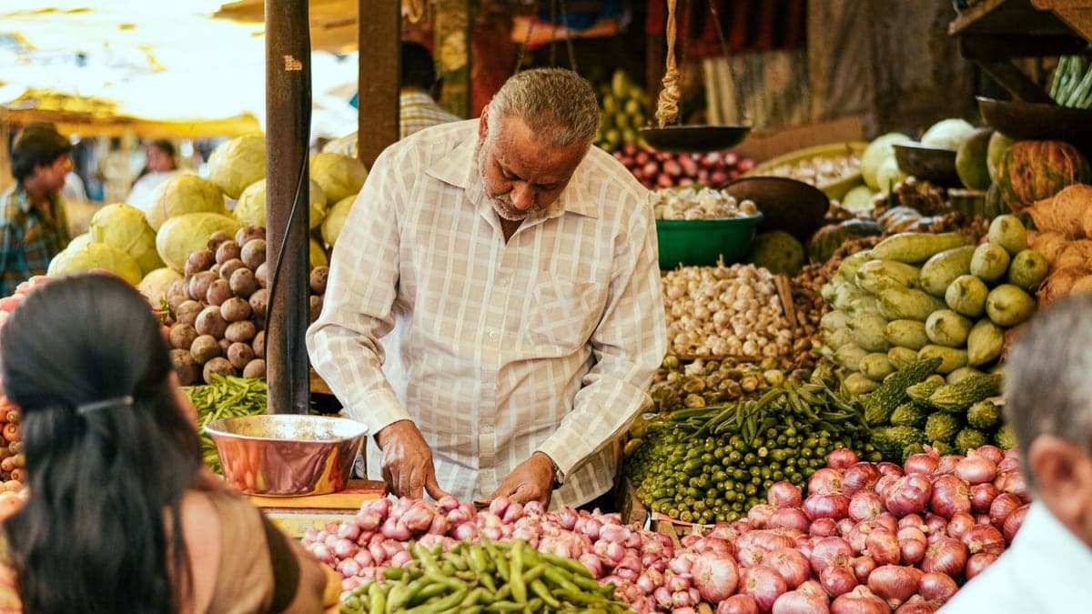 Vendor selling vegetables at a local market in India.