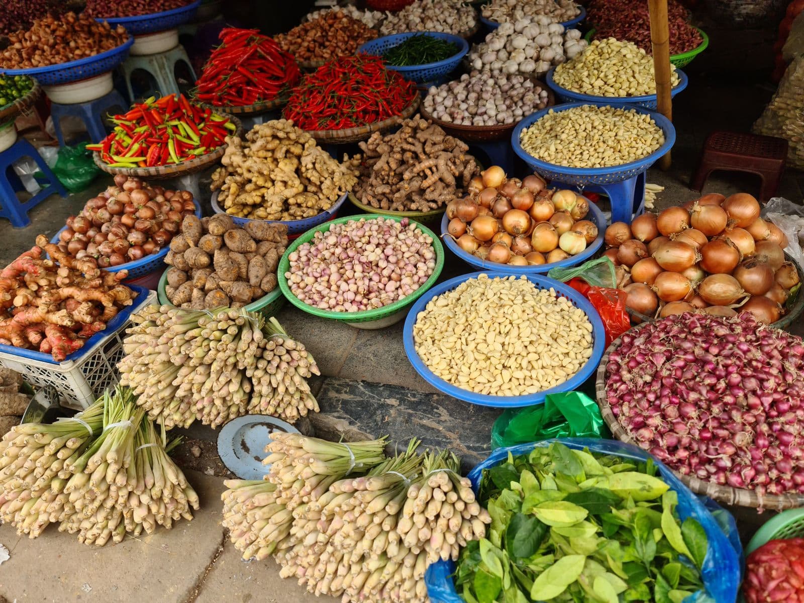 Traditional Vietnamese food market in Hanoi with fresh produce, herbs and street-food stalls.